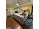 Bright bedroom featuring a ceiling fan, dresser and a bed with a floral comforter at 5363 Forest Dr, Loganville, GA 30052