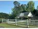 Community clubhouse with white picket fence, black chainlink fence and lush green landscape at 5363 Forest Dr, Loganville, GA 30052