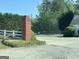 Community parking lot with white picket fence, brick pillar and lush green landscape at 5363 Forest Dr, Loganville, GA 30052