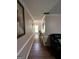 Long hallway with hardwood floors, neutral walls, and decorative art leading to the front door at 5363 Forest Dr, Loganville, GA 30052