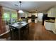 Open kitchen features a dining table, white cabinets, stainless steel appliances, and large windows at 5363 Forest Dr, Loganville, GA 30052