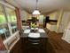 Bright kitchen with hardwood floors, white cabinets, stainless appliances, and a cozy dining area at 5363 Forest Dr, Loganville, GA 30052