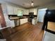 Well-lit kitchen with white cabinets, stainless steel appliances, hardwood floors, and black tile backsplash at 5363 Forest Dr, Loganville, GA 30052