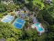 Aerial showcasing community tennis courts and pool with inviting clubhouse surrounded by lush trees at 100 Trotters Rdg, Fayetteville, GA 30215