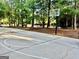 Community concrete basketball court surrounded by a wooded area, with a basketball hoop at 100 Trotters Rdg, Fayetteville, GA 30215