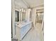 Well-lit bathroom featuring a double vanity with granite countertops and a view to a walk-in closet at 100 Trotters Rdg, Fayetteville, GA 30215