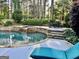 This inviting pool area features a rock retaining wall, waterfall, and comfortable outdoor seating at 100 Trotters Rdg, Fayetteville, GA 30215