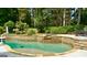 Beautiful backyard swimming pool with a stone wall and lush greenery at 100 Trotters Rdg, Fayetteville, GA 30215