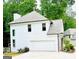 Exterior featuring a two-car garage, well-maintained lawn, and lush greenery at 2870 Willow Wisp Way, Cumming, GA 30040