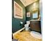 Stylish powder room with dark green walls, and wood-look flooring, providing a chic and functional space at 2870 Willow Wisp Way, Cumming, GA 30040
