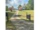 Exterior view of the home with a long driveway, blooming trees and grass at 732 Sandhill Shady Grove Rd, Carrollton, GA 30116