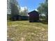 Exterior view of outbuildings on a grassy, partially overgrown property at 732 Sandhill Shady Grove Rd, Carrollton, GA 30116