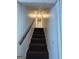 Interior view of a carpeted staircase with white walls and wooden handrail at 732 Sandhill Shady Grove Rd, Carrollton, GA 30116