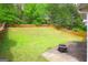 Landscaped backyard with a wooden fence, lush lawn, and fire pit area, perfect for outdoor living at 25 Pacific Ave, Sharpsburg, GA 30277