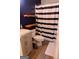 Stylish bathroom with a modern vanity, floating shelves, and a shower with a striped curtain at 25 Pacific Ave, Sharpsburg, GA 30277