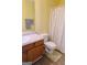 Cozy bathroom with laminate floors, vanity, and a shower with neutral colored shower curtain at 25 Pacific Ave, Sharpsburg, GA 30277