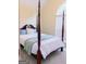 Bedroom featuring a four-poster bed, soft carpet, and a window with natural light at 25 Pacific Ave, Sharpsburg, GA 30277