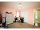 Bedroom showcasing a chest of drawers, desk, and doorway to a room with hardwood floors at 25 Pacific Ave, Sharpsburg, GA 30277