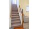 Carpeted staircase with a white and wood banister leading to an open living area at 25 Pacific Ave, Sharpsburg, GA 30277