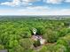 Stunning aerial view of a lush, wooded property with a beautiful home and private pool at 400 Peachtree Pkwy, Peachtree City, GA 30269