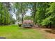 Sprawling backyard with mature trees, lush lawn, and a trampoline at 400 Peachtree Pkwy, Peachtree City, GA 30269