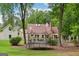 Well-maintained backyard features lawn, mature trees, and trampoline at 400 Peachtree Pkwy, Peachtree City, GA 30269