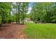 Spacious backyard with lush trees, fencing, and a well-manicured lawn at 400 Peachtree Pkwy, Peachtree City, GA 30269