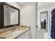 Bathroom with granite countertops, white cabinets, large mirror, and access to bedroom and hallway at 400 Peachtree Pkwy, Peachtree City, GA 30269