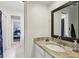 Bathroom with granite countertop, large mirror, white cabinets, and access to bedroom at 400 Peachtree Pkwy, Peachtree City, GA 30269