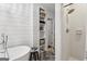 Bright bathroom with soaking tub, tiled shower, and built-in shelving for towels and decorative items at 400 Peachtree Pkwy, Peachtree City, GA 30269