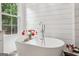 Bright bathroom featuring a standalone tub with a large window, flowers, and modern fixtures at 400 Peachtree Pkwy, Peachtree City, GA 30269