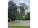 Long driveway leading to a beautiful home surrounded by mature trees and landscaping at 400 Peachtree Pkwy, Peachtree City, GA 30269