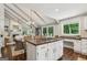 Open-concept kitchen with large island and eat-in area flowing into a bright living space with vaulted ceilings at 400 Peachtree Pkwy, Peachtree City, GA 30269