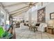 Open-concept living room with vaulted ceilings, exposed beams, and white sofas, showcasing the kitchen at 400 Peachtree Pkwy, Peachtree City, GA 30269