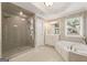 Bright bathroom featuring a glass shower, a soaking tub, and a vanity with ample storage at 891 Berryman Pl, Lawrenceville, GA 30045