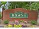 Welcoming brick community sign with vibrant flowerbeds at 'The Downs' at 891 Berryman Pl, Lawrenceville, GA 30045