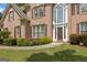 Close-up of a brick home with an arched entryway, trimmed shrubs, and well-kept lawn at 891 Berryman Pl, Lawrenceville, GA 30045