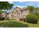 Brick home with manicured lawn and mature trees, features a side view of neighboring property at 891 Berryman Pl, Lawrenceville, GA 30045
