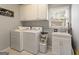 Well-organized laundry room with sink, overhead cabinets, and neutral decor at 891 Berryman Pl, Lawrenceville, GA 30045