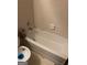 Bathroom bathtub featuring white tiling and a shower fixture with a toilet in view at 1975 Longwood Ct, Lithonia, GA 30058