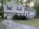 Charming split-level home featuring a brick facade, garage, and well-maintained front yard at 1975 Longwood Ct, Lithonia, GA 30058