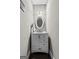 Powder room featuring vanity with storage, an oval mirror, and modern light fixture at 240 Sturry Dr # 71, Mcdonough, GA 30252