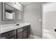 Bathroom featuring dark brown cabinets, a white countertop, framed mirror, and tiled floors, offering a clean and stylish design at 240 Sturry Dr # 71, Mcdonough, GA 30252