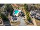 Aerial view of community pool with a parking lot and clubhouse, enhanced by trees at 240 Sturry Dr # 71, Mcdonough, GA 30252