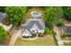 Overhead view of white two-story home, lush lawn, mature trees, in-ground pool and circular driveway at 608 Bellenden Dr, Peachtree City, GA 30269