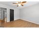 Empty bedroom featuring wood laminate flooring, a ceiling fan, and black doors at 608 Bellenden Dr, Peachtree City, GA 30269