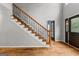 Foyer view of hardwood floors, staircase with decorative ironwork, and entry door at 608 Bellenden Dr, Peachtree City, GA 30269