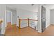 Hallway featuring wood laminate flooring, wood railing with decorative iron, and light gray walls at 608 Bellenden Dr, Peachtree City, GA 30269