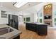 Open-concept living space with stone fireplace, a wall of windows, hardwood floors, and modern kitchen at 608 Bellenden Dr, Peachtree City, GA 30269