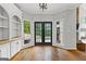 Well-lit living room with built-in shelves, hardwood floors, and a glass door leading to the backyard at 608 Bellenden Dr, Peachtree City, GA 30269